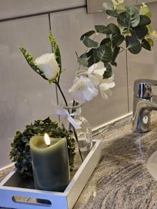 een kaars en bloemen in een vaas op een toonbank bij Ferienwohnung Goldstr.7 in Quedlinburg