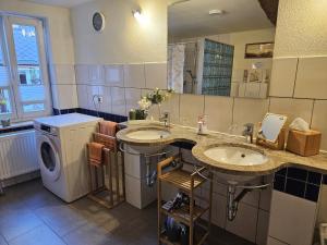 een badkamer met 2 wastafels en een wasmachine bij Ferienwohnung Goldstr.7 in Quedlinburg +46 foto's