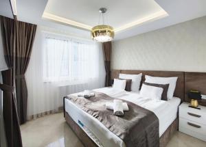 - une chambre avec un grand lit et 2 serviettes dans l'établissement Royal Liberty Apartment, à Keszthely