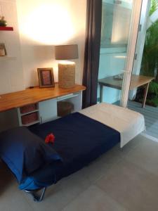 a bedroom with a desk and a blue bed at La Perle de Trou d'Eau in La Saline les Bains