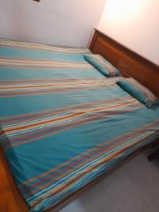 een bed met blauwe lakens en kussens erop bij JANA HOUSE in Galle