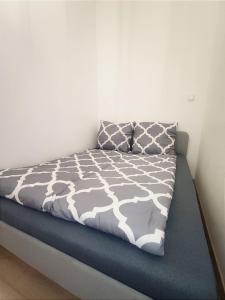 łóżko z szarą i białą kołdrą oraz poduszką w obiekcie Silesia Comforts Katowice, Chorzów SELF CHECK w mieście Chorzów