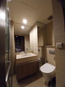 a bathroom with a sink and a toilet and a mirror at Apartemen Uttara the Icon in Yogyakarta