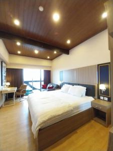a bedroom with a large bed and a desk at Apartemen Uttara the Icon in Yogyakarta