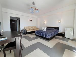 a bedroom with a bed and a table and a couch at Edmond in Eforie Sud