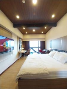 a bedroom with a large white bed in a room at Apartemen Uttara the Icon in Yogyakarta