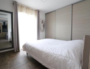 um quarto com uma grande cama branca e um espelho em MAISON à AJACCIO tout CONFORT 4-5pers em Ajaccio