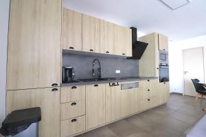 uma cozinha com armários de madeira e um lavatório em MAISON à AJACCIO tout CONFORT 4-5pers em Ajaccio