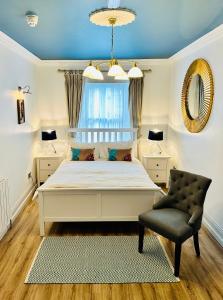 a bedroom with a white bed and a chair at Zoe Bistro & Accommodation in Kilrush