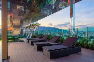 a row of chairs on a balcony with a view of a city at Luxury and modern condo in Central Chiang Mai - Astra Condo in Chiang Mai