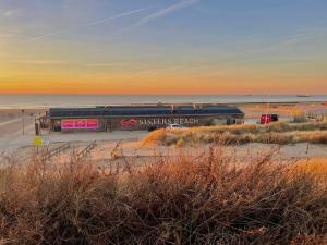 a train station on the beach at sunset at Sisters Beachbungalows in Katwijk aan Zee +6 photos