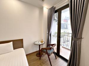 1 dormitorio con cama, mesa y ventana en Au79 Hotel & Apartment, en Hai Phong