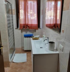 y baño con lavabo y ducha. en Goccia in Valdorcia Smart Home, en San Quirico dʼOrcia