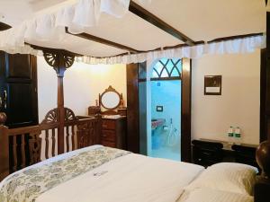 a bedroom with a bed and a bathroom at Mendes in Mapusa