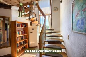 una escalera de caracol en una casa con estanterías en Ferienhaus-Schwarzwald-Imbirkenweg-bei-Strassburg-Europapark-fuer-1-12-Personen en Rheinau