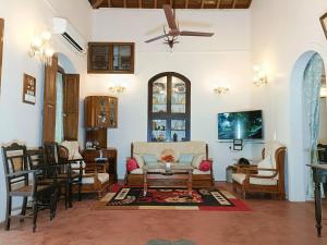 a living room with a couch and a table and chairs at Mendes in Mapusa