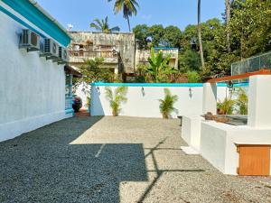 a house with a white fence and palm trees at Mendes in Mapusa
