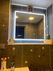 baño con espejo en la pared y lavabo en Corner Guest House, en Tiflis