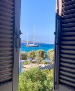 a view of a sail boat in the ocean from a window at The Blue Lagoon Apartment in Aliki