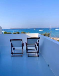 two chairs sitting on the edge of a roof at The Blue Lagoon Apartment in Aliki