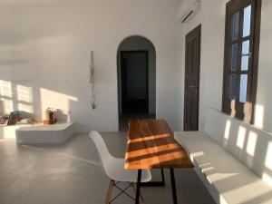 a white room with a chair and a table at The Blue Lagoon Apartment in Aliki