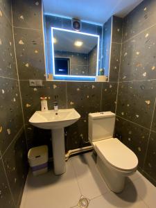 a bathroom with a sink and a toilet and a mirror at Corner Guest House in Tbilisi City