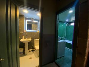 a bathroom with a sink and a toilet and a mirror at Corner Guest House in Tbilisi City