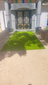 a front door of a house with a green lawn at Sama Stars Hotel in Abu Simbel