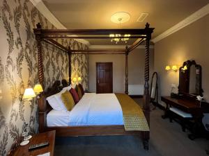 um quarto com uma cama de dossel e um piano em Darnley Lodge Hotel em Athboy