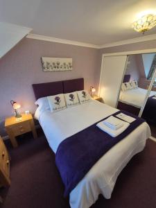 um quarto de hotel com uma cama grande e um espelho em Montague Villa em Dunoon
