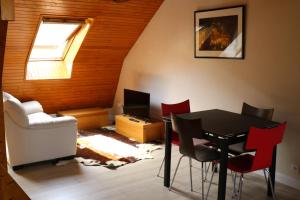 a living room with a table and red chairs at Les rives de l'odet, vue rivière in Quimper