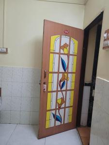 een deur met een glas-in-loodraam in een badkamer bij JAI MALHAR LODGE in Pune