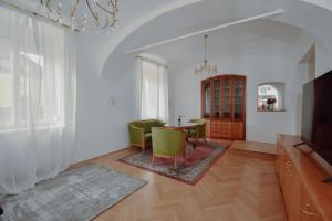 a living room with a table and green chairs at Altbau-Traum in Feldbach in Feldbach