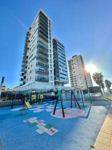 um parque vazio em frente a um edifício alto em Habitación en la Bahía de Cádiz em San Fernando