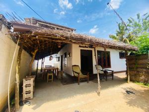 a small house with a thatched roof at Anosha Villa in Weligama