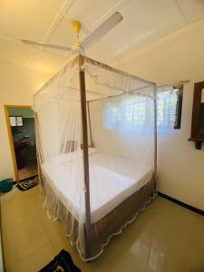 a bedroom with a bed with mosquito net at Anosha Villa in Weligama