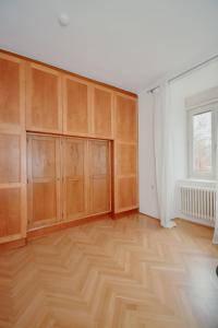 an empty room with wooden cabinets and a window at Altbau-Traum in Feldbach in Feldbach