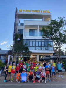a group of people posing in front of a hotel at HA PLEIKU in Pleiku