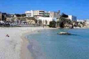una vista di una spiaggia con edifici sullo sfondo di House Pedone a Otranto