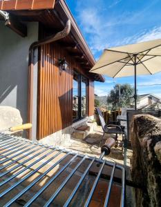 a patio with a table and an umbrella and a chair at Pura Vida Matos House in Fafião