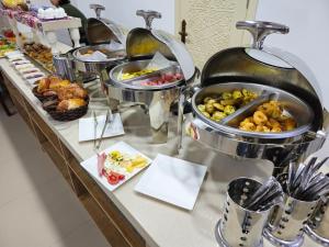 uma linha de buffet com muitos tipos diferentes de alimentos em Khan Hotel Samarkand em Samarkand