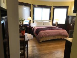 1 dormitorio con 1 cama grande y 2 ventanas en Vancouver guest house en Vancouver