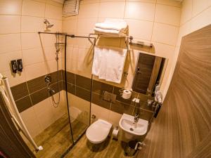 a bathroom with a shower and a toilet and a sink at New Akçaabat Hotel in Akcaabat