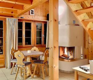 une salle à manger avec une table et une cheminée dans l'établissement Duplex des Préalpes fribourgeoises, à Jaun