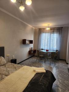 a bedroom with a bed and a dining room table at Garni Nature Villa in Garni