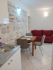 cocina con mesa y sofá rojo en Apartment Andela, en Kaštela
