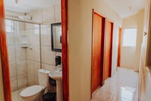 a bathroom with a toilet and a sink at Hostel Casarão Fronteira in Santana do Livramento