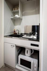 a small kitchen with a sink and a microwave at bHOTEL Yutori - Homey w 1BR in Onomichi for 3 Ppl in Onomichi