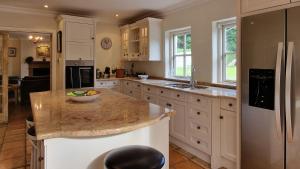 a kitchen with white cabinets and a granite counter top at Tranquil 18th Century with tennis court in Malahide