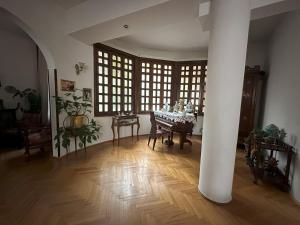 a living room with a table and a large window at Hotel Home in Tbilisi City